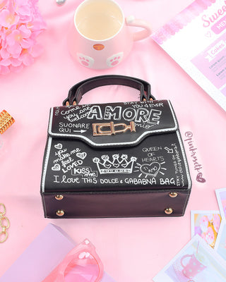 Bolso negro con estampado letras y herraje dorado