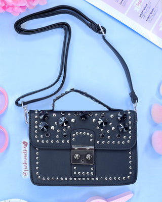 Bolso negro con aplique de pedrería negra y taches