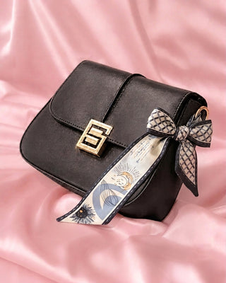 BOLSO NEGRO CUADRADO CON BROCHE DE LETRA S DORADA