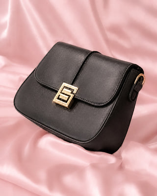 BOLSO NEGRO CUADRADO CON BROCHE DE LETRA S DORADA