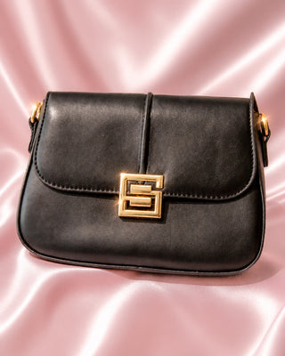 BOLSO NEGRO CUADRADO CON BROCHE DE LETRA S DORADA