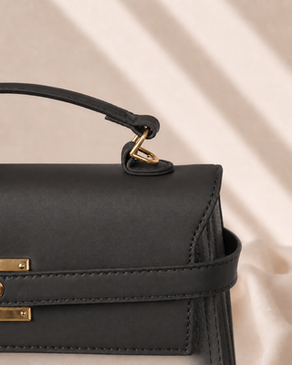 BOLSO NEGRO CUADRADO CON TAPA Y BROCHE DORADO