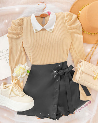 Falda short negra con tapa, taches plateados y lazo