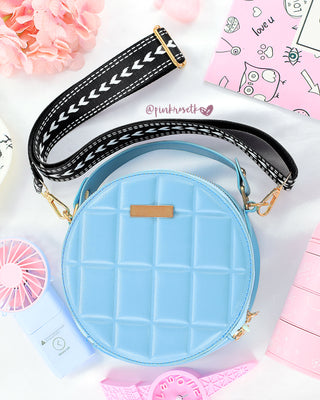 Bolso redondo azul con correa negra y blanco