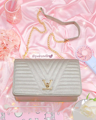 Bolso con doble cadena de broche en v dorado